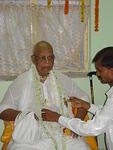A devotee garlanding Baba